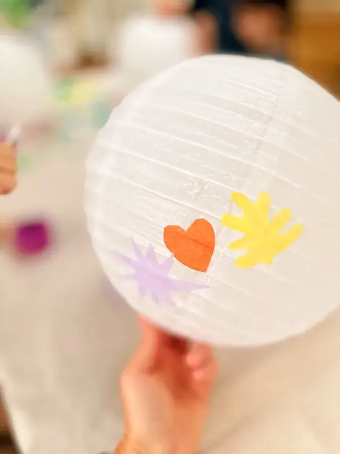 A close-up of a paper lantern decorated with a heart and stars