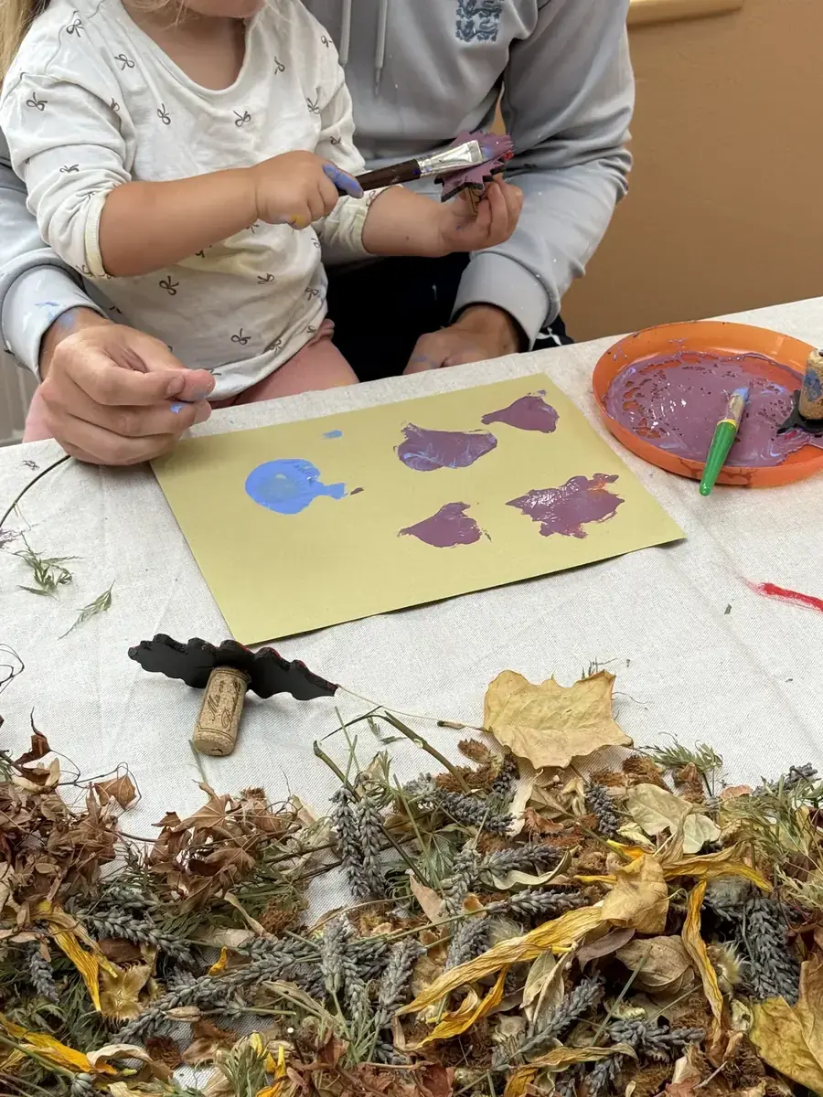 A child printing purple shapes onto yellow paper